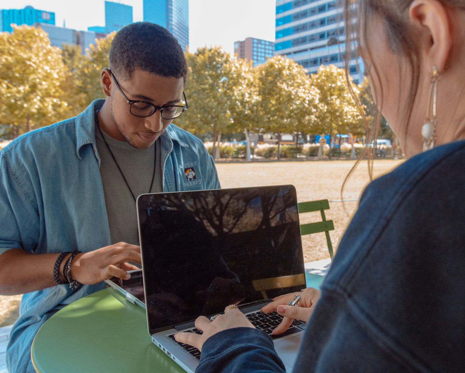 Gen z :man and woman sitting while using MacBook Pro